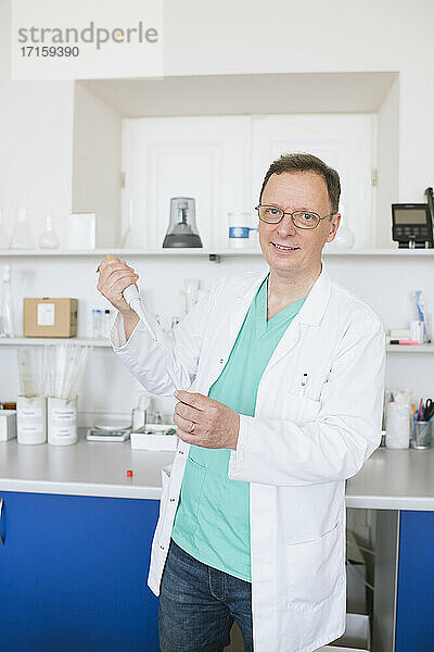 Porträt eines Forschers im weißen Kittel bei der Arbeit im Labor