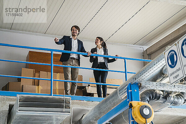 Business people smiling while checking machinery at industry