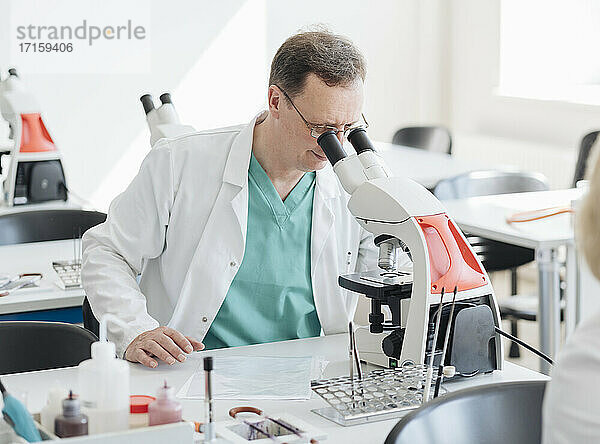 Senior-Forscher bei der Arbeit mit dem Mikroskop im Labor