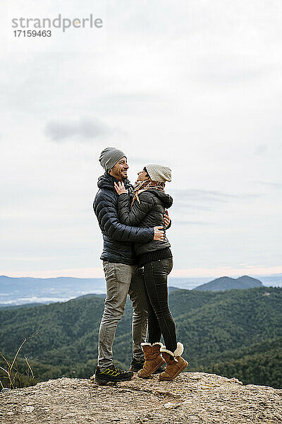 Glückliches Paar  das sich am Aussichtspunkt umarmt