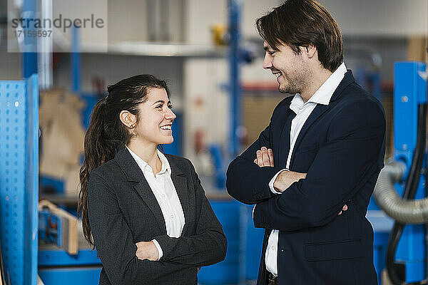 Young business people smiling while standing at industry