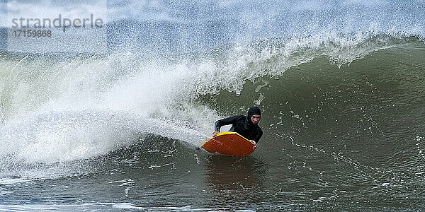 Älterer männlicher Brettsurfer beim Bodyboarden im Meer bei Broad Haven South  UK