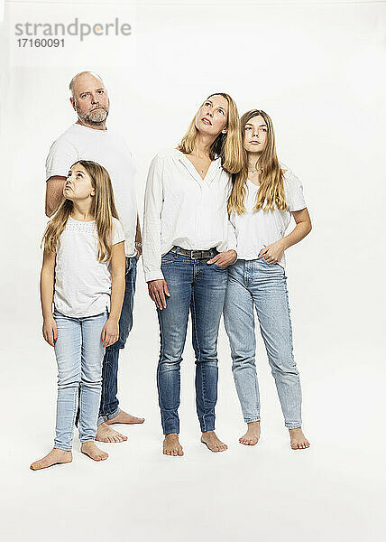 Daughters with parents looking away while standing in studio