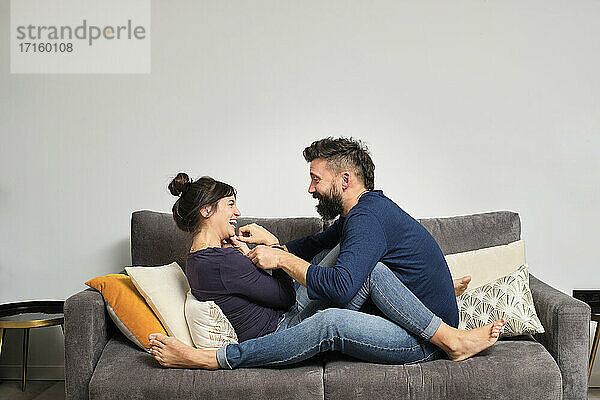 Erwachsenes Paar sitzt zusammen auf dem Sofa