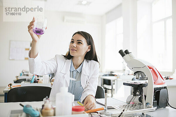 Junge Forscherin im weißen Kittel bei der Arbeit im Labor
