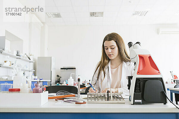 Junger Forscher im weißen Kittel bei der Arbeit in einem Labor
