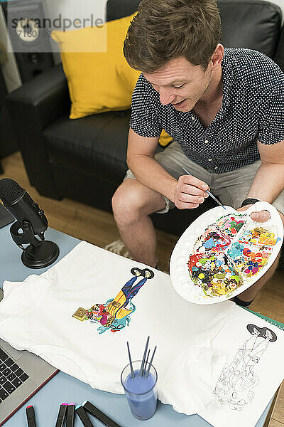 Künstlerin malt Kritzelei auf T-Shirt während Live-Streaming zu Hause