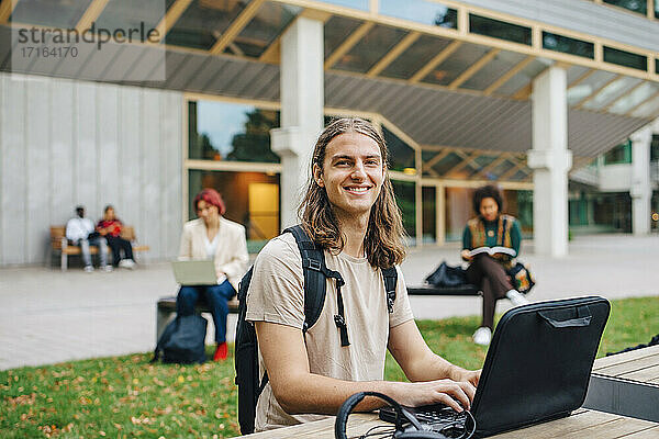 Porträt männlicher Studenten E-Learning durch Laptop auf dem Universitätscampus