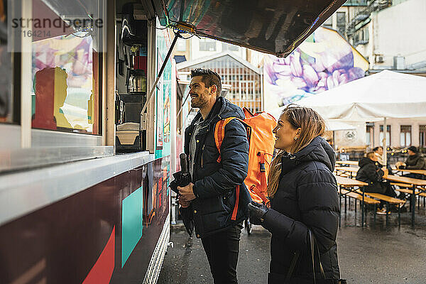 Glückliches Paar steht an der Theke eines Food Trucks