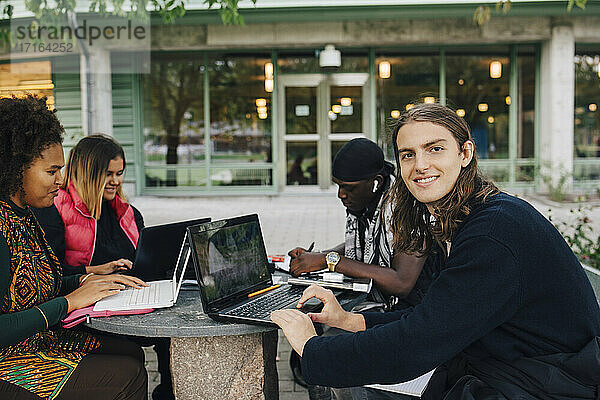 Lächelnder Universitätsstudent  der im College studiert