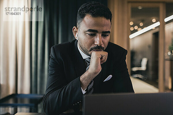 Angespannt Geschäftsmann Blick auf Laptop beim Sitzen im Sitzungssaal