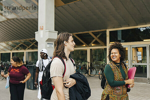 Männliche und weibliche Studenten zu Fuß in College-Campus