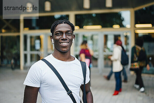 Porträt eines lächelnden afrikanischen Studenten auf dem Campus