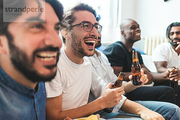 Mann  der Bier trinkt und zusammen fernsieht  lachend