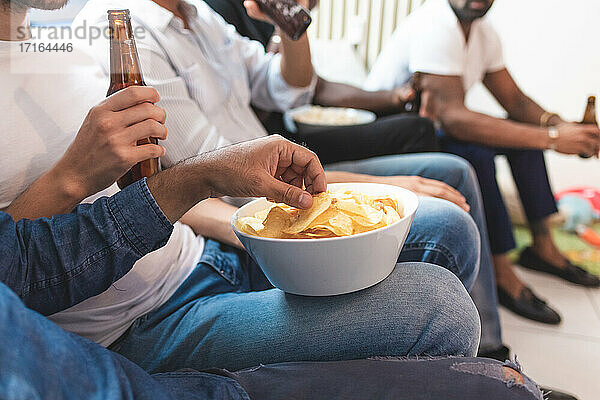 Männer bei Bier und Snacks