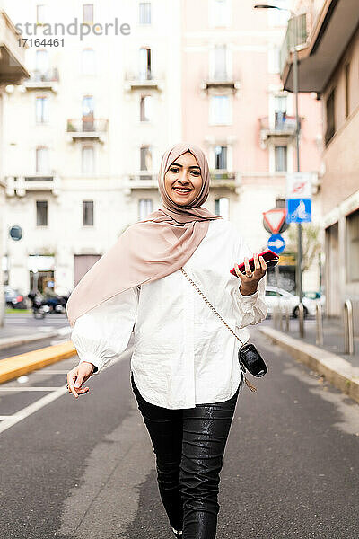 Junge muslimische Frau zu Fuß in der Stadt