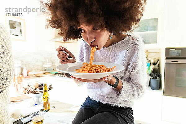 Junge Frau isst Spaghetti