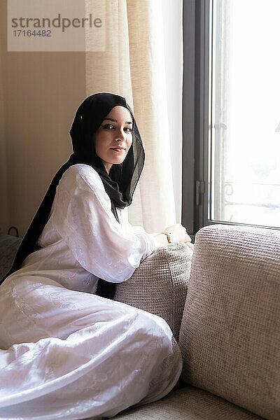 Junge muslimische Frau entspannt sich zu Hause