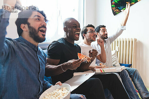 Männer essen Pizza und jubeln