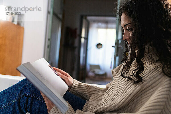 Junge Frau liest zu Hause
