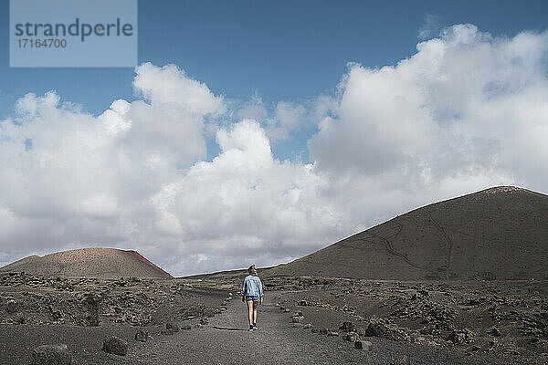 Forscher auf Wanderweg gegen den Himmel am Vulkan El Cuervo  Lanzarote  Spanien
