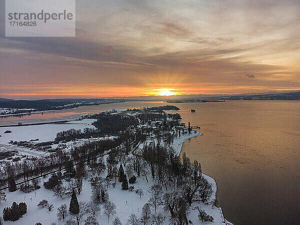 Germany  Baden-Wurttemberg  Radolfzell  Aerial view of snow-covered Mettnau peninsula at sunset