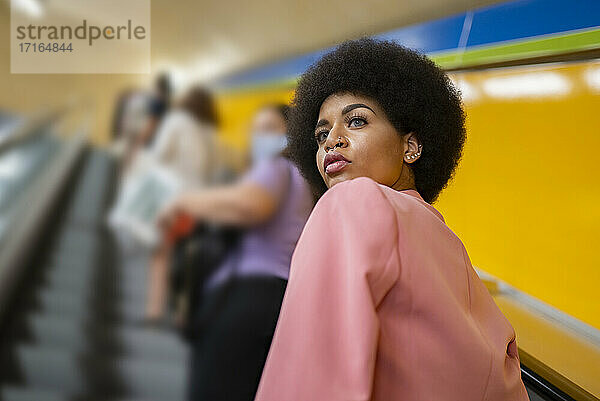 Female hipster on escalator at subway station