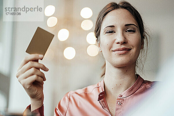 Weibliche Kundin beim Bezahlen mit Kreditkarte in einem Cafe