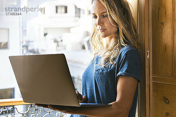 Woman concentrating while using laptop at home