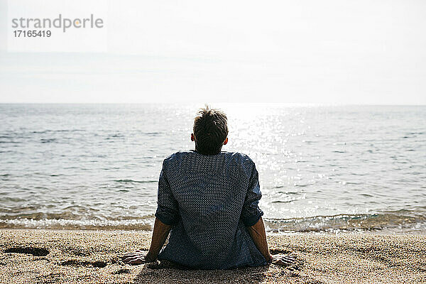 Mann entspannt sich am Strand an einem sonnigen Tag