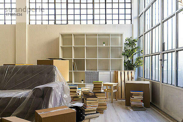 Interieur der neuen Wohnung mit Bücherstapel und Möbeln