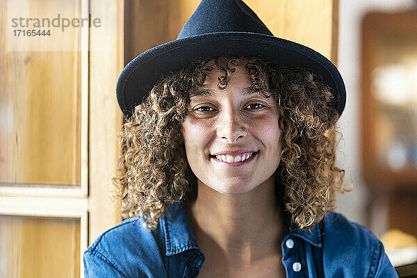 Young smiling woman wearing hat at home