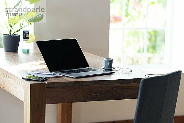Smartphone und Laptop auf dem Tisch im Heimbüro