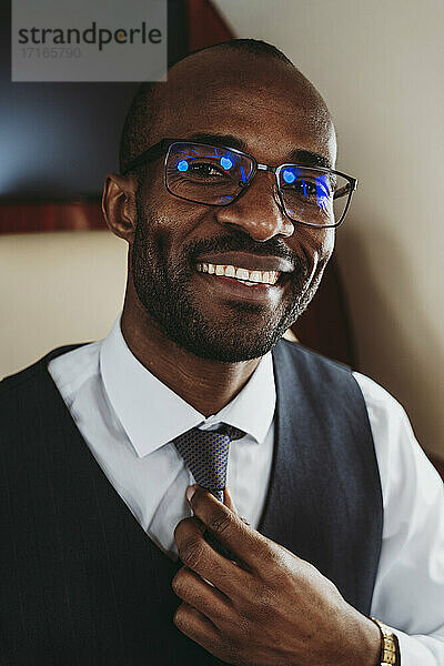 Lächelnder männlicher Unternehmer mit Krawatte im Flugzeug