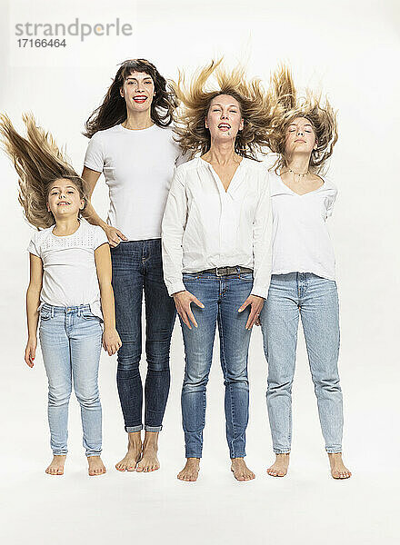 Mothers and daughters with tousled hair against white background