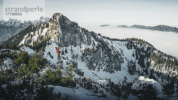 Deutschland  Bayern  Ammergauer Alpen  Teufelstattkopf  Tourist beim Bergwandern an einem Wintertag