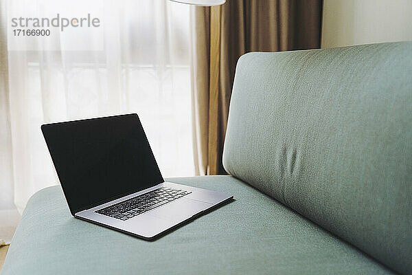 Laptop on sofa in hotel room