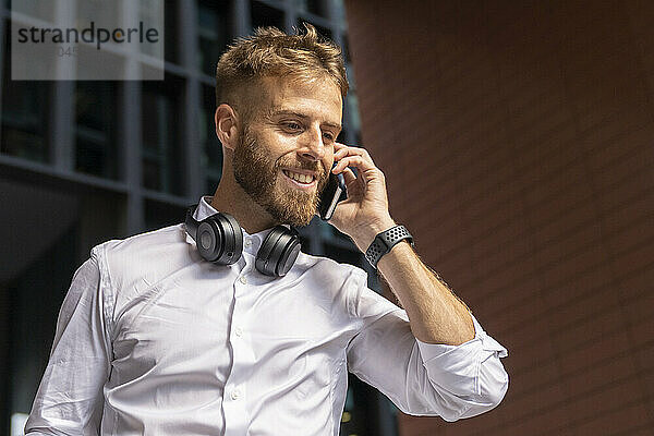 Businessman talking on smart phone while standing outdoors