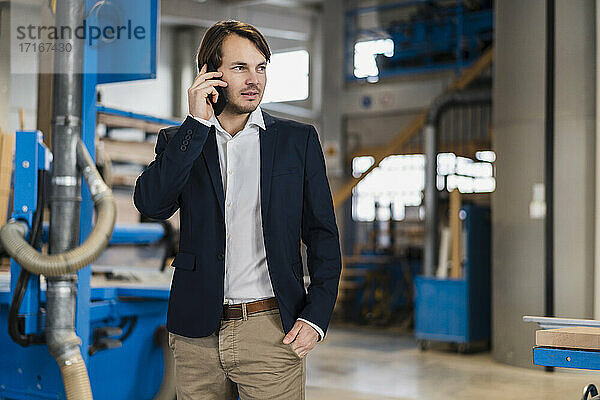 Young businessman talking on mobile phone while standing
