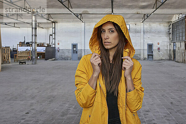 Modern dancer with long hair in yellow jacket at abandoned factory