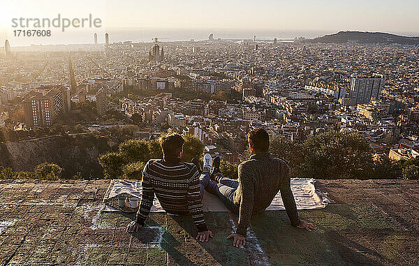 Homosexuell Freunde Blick auf überfüllten Stadtbild beim Sitzen auf Aussichtspunkt  Bunkers del Carmel  Barcelona  Spanien