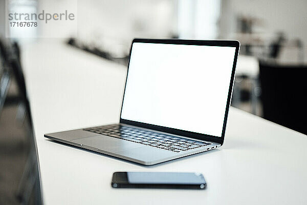 Laptop und Smartphone auf dem Tisch im Büro