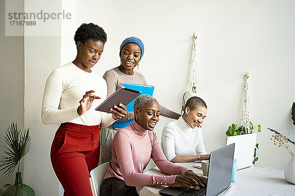 Smiling multi-ethnic female colleagues working at home