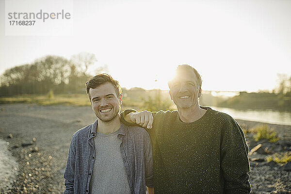 Happy father and son against clear sky at evening