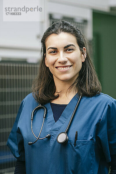 Smiling female veterinarian in blue uniform with stethoscope in hospital