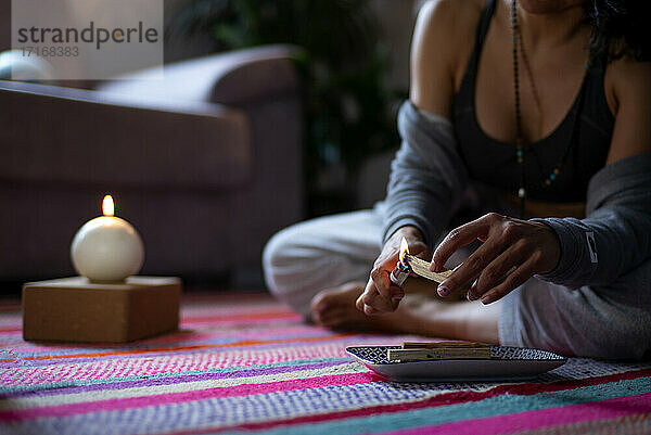 Spiritual woman burning wood at home