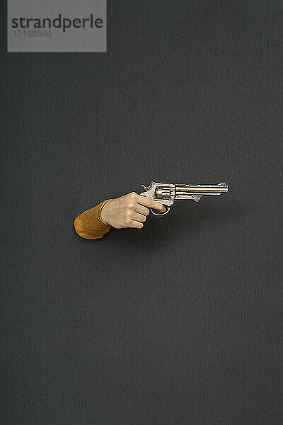 Studio shot of female hand holding old-fashioned revolver