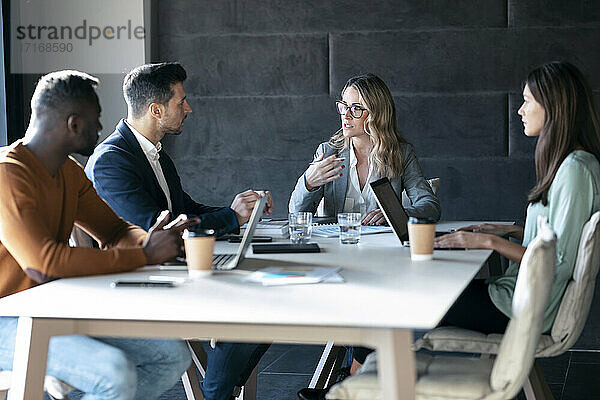 Business people having discussion in meeting while sitting at office