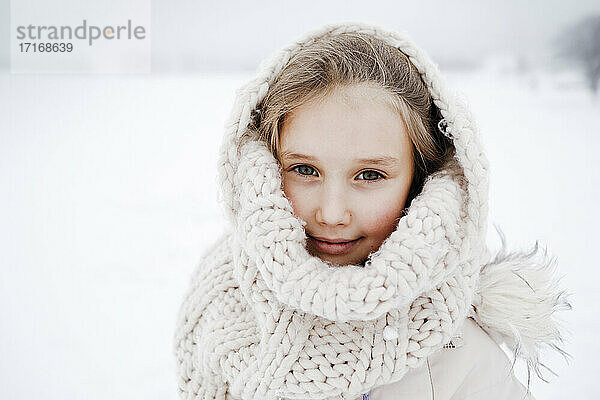Kleines Mädchen mit Strickschal im Winter