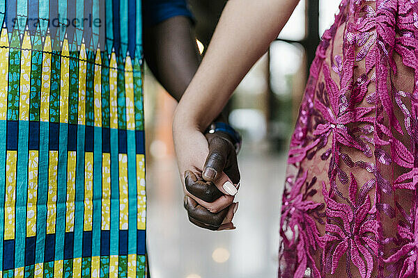 Young couple holding hands while standing at banquet